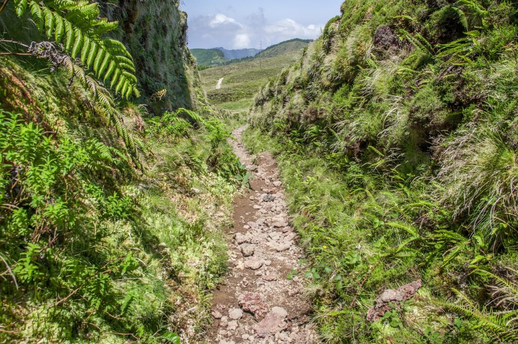 Senderista en el sendero costero de São Jorge con vistas al océano Atlántico
