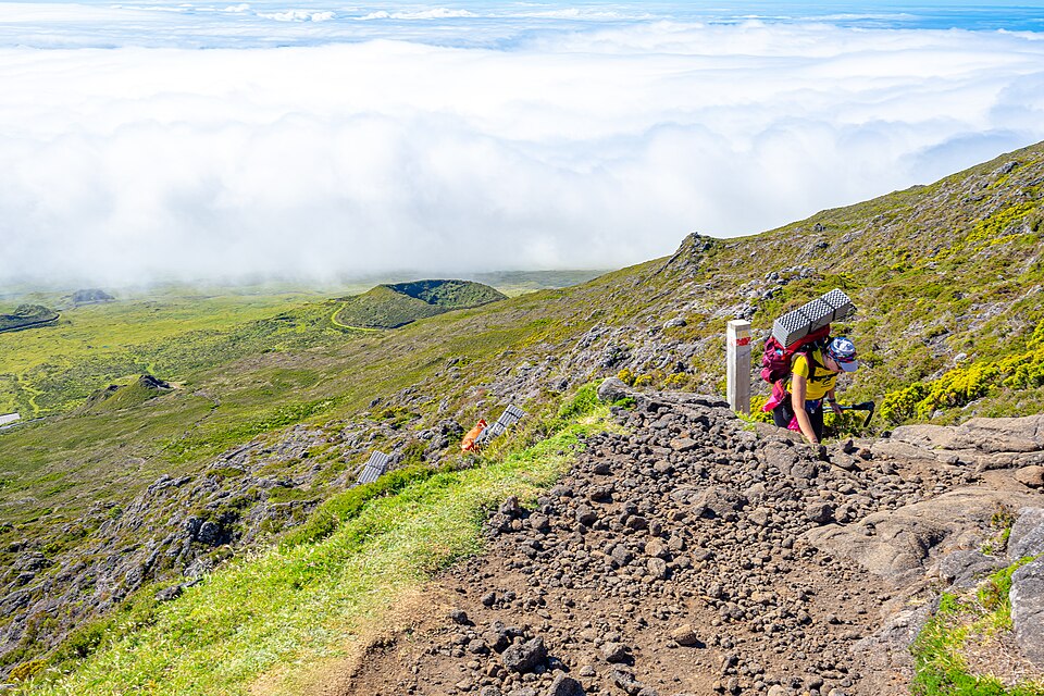 Hiker climbing Mount Pico above the clouds in the Azores Hiker climbing Mount Pico above the clouds in the Azores