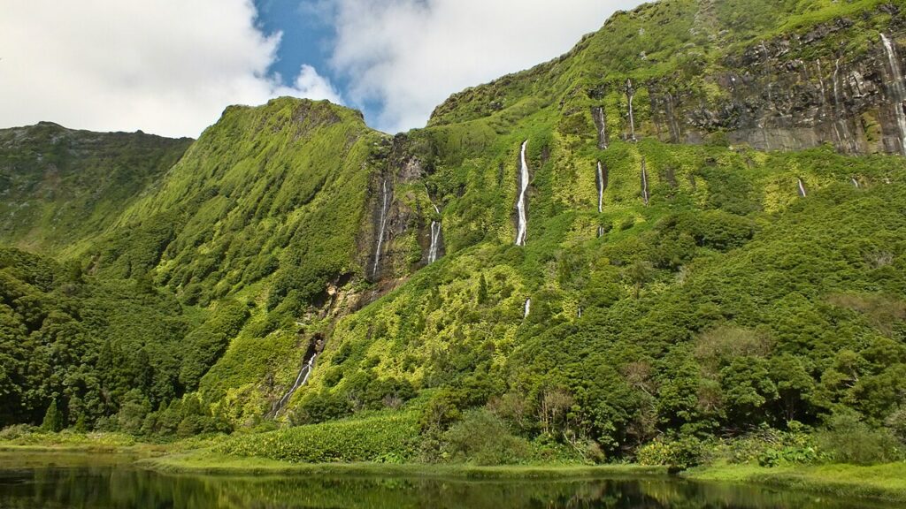 Waterfalls descending a green cliff on Flores Island, Azores
