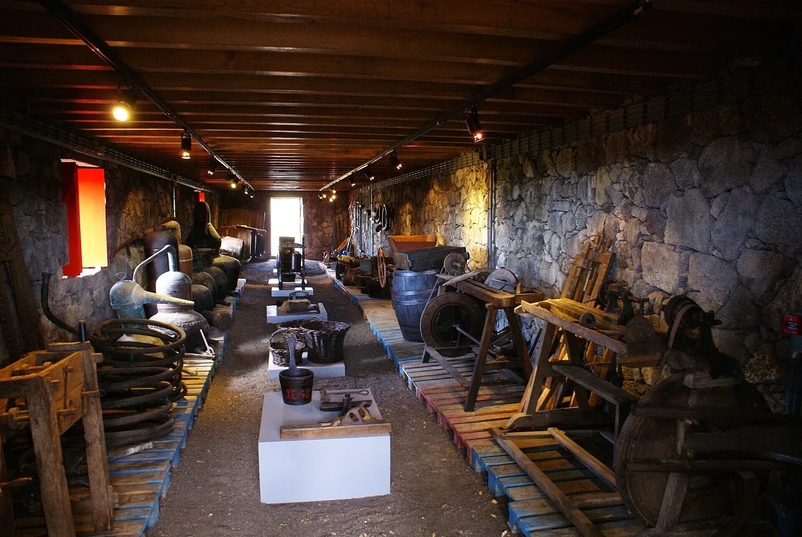 Interior de una bodega histórica con barriles y herramientas en el Museo del Vino de Pico